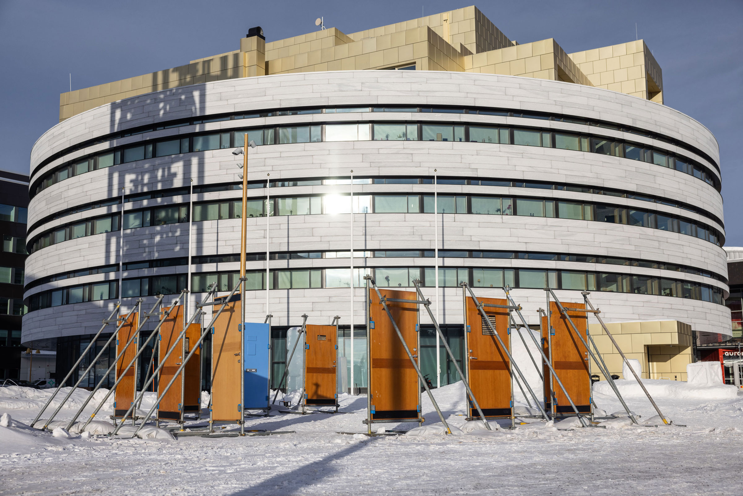 An art installation by Jenny Nordmark consisting of doors stading in th epublic space of the new city center of Kiruna, a city in northern Sweden. Part of the Luleå Biennial curated by Bruno Alves de Almeida and Aude Christel
